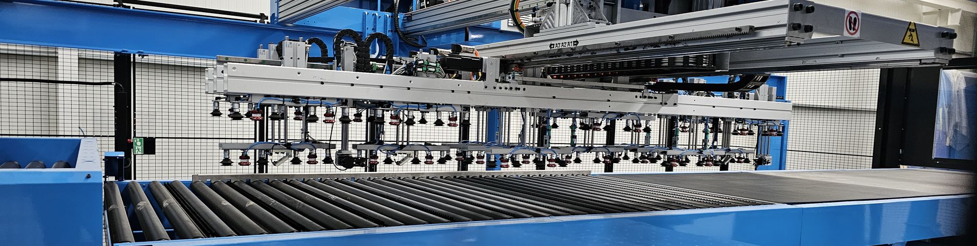 Gantry robot with suction cups above a roller conveyor